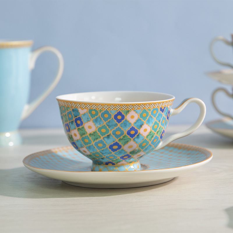 Taza de té con plato en porcelana con vistoso mosaico en azules.